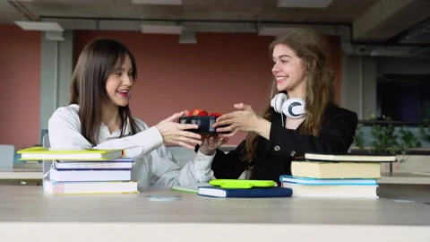 Friendly students having apples at break. Two girls at lunch time in school Video stock 243322832