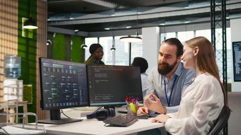 Friendly team leader helping happy young engineer code AI algorithms Stock-Footage 313168341