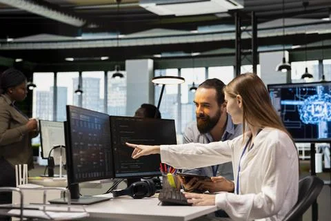 Friendly team leader mentor explaining young software engineer how to use AI Stock Photos