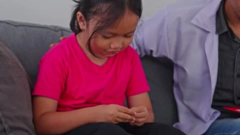 Friendly therapist putting hand on young girl's shoulder to reassure and Stock Footage 340259392