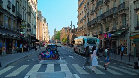 Friendly tourists waving while crossing the road on a busy day in Paris, France. Stock Footage 245453425