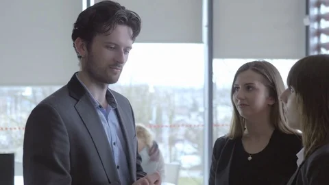 Friendly worker greeting his colleagues in the office Stock Footage 75825132