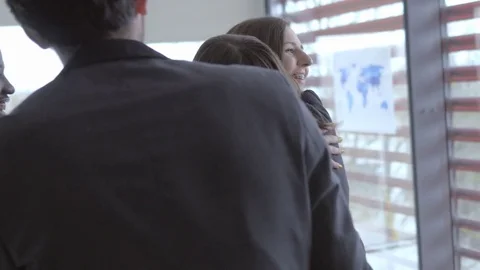 Friendly workers hugging with each other in the workplace Stock Footage 74308546