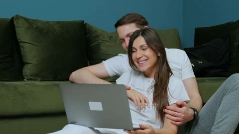 Friendly young couple having video call with relatives, waving to laptop screen. Stock Footage 148949984