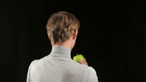 Friendly young guy offering a green apple at camera Stock Footage 70306890