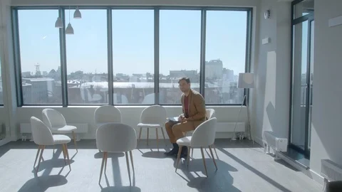 Friendly young HR manager in formal clothes invites a multi-ethnic staff Stock Footage 128448356