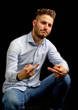  Friendly young man doing fuck you gesture with middle fingers Friendly yo... Stock Photos