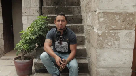 Friendly Young Man Smiling, Sitting in Urban Environment Stockbeeldmateriaal 52348758