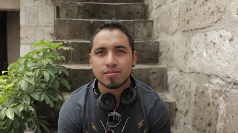 Friendly Young Man Smiling, Sitting in Urban Environment Stock Footage 52348799