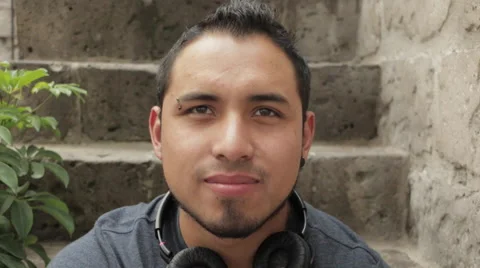 Friendly Young Man Smiling, Sitting in Urban Environment Stock Footage 52348807