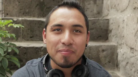 Friendly Young Man Smiling, Sitting in Urban Environment Stock Footage 52348809