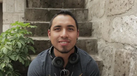 Friendly Young Man Smiling, Sitting on Stairs, Close Up Shot Stock Footage 52348817