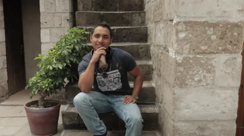 Friendly Young Man Smiling, Sitting in Urban Environment Stock Footage 52348822