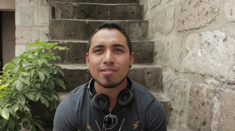 Friendly Young Man Smiling, Sitting in Urban Environment Stock Footage 52354529