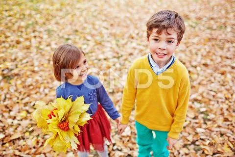 Friendly youngsters walking in park in autumn Stock Photos