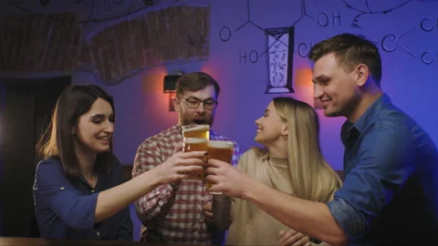 Friends are drinking beer at a pub. Five friends dressed in casual clothing Stock Footage 240043365