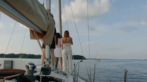 Friends are standing on the bow of a sailing boat and drinking wine Stock Footage 201192041