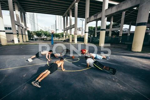 Friends On Basketball Court In A Circle Doing Push Ups