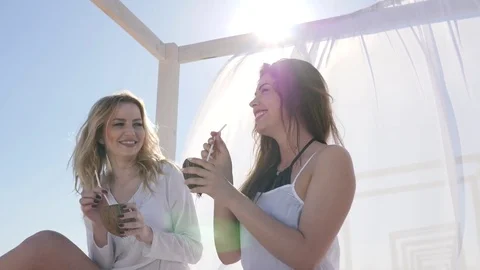 Friends on beach, on background bungalow, wind develops white 動画素材 76972312