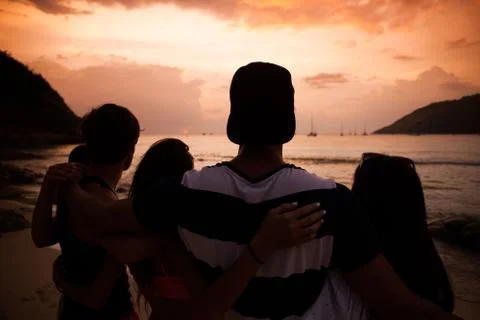 Friends on beach at sunset Stock Photos