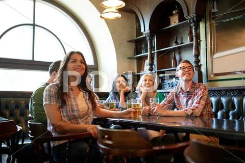 Friends with beer watching football at bar or pub Stock Photos