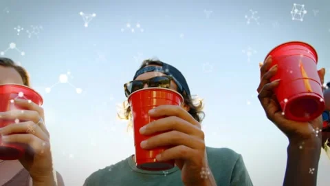 Friends bringing red cups above camera, clinking and drinking, toasting Stockbeeldmateriaal 330756686