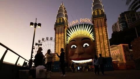 Friends chat in front of Luna Park in Sydney evening time 6K Stock Footage 308498309