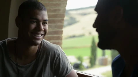 Friends chattering indoor in front of a window Vídeo Stock 64518016