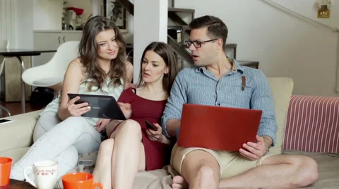Friends chatting and using modern technology on the sofa Stock Footage 54087194
