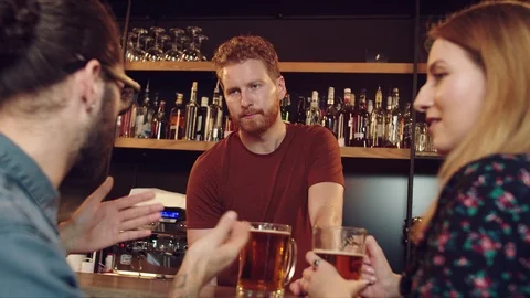 Friends chatting with batrender at pub. Stock Footage 125083274