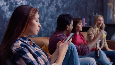 Friends Chatting Drinking Beer at Home. Girl is Chatting on Phone. Not with Stock Footage 217889652