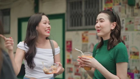 Friends chatting outdoors while holding iced drinks Stock Footage 319757742