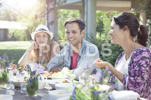 Friends chatting while enjoying healthy meal together Stock Photos