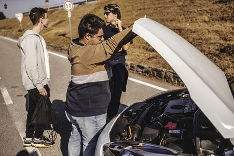 Friends checking car engine troubleshooting roadside breakdown Stock Photos