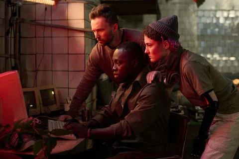 Friends Checking Data On Old Computer In Post-apocalyptic Shelter Fotos de archivo