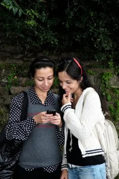 Friends checking message on mobile phone. Stock Photos