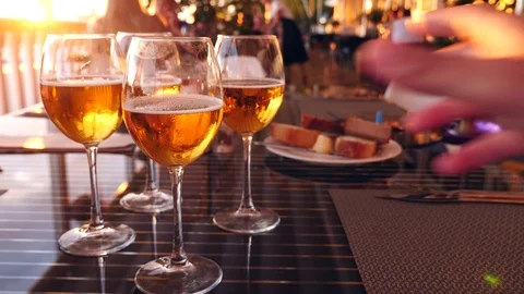Friends clink glasses with alcohol in a restaurant by the sea. close-up. slow Stock Footage