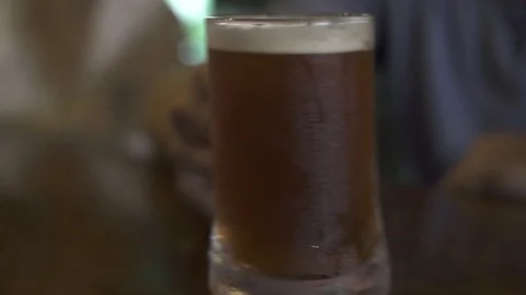 Friends clinking beer mug in bar pub close up. People holding cold beer mug and Stock Footage 104386445