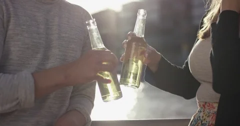 Friends clinking bottles and drinking satisfied Stock Footage 79090197