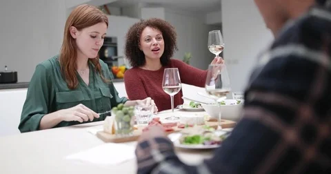 Friends clinking glasses over a meal together Stock Footage 80792725