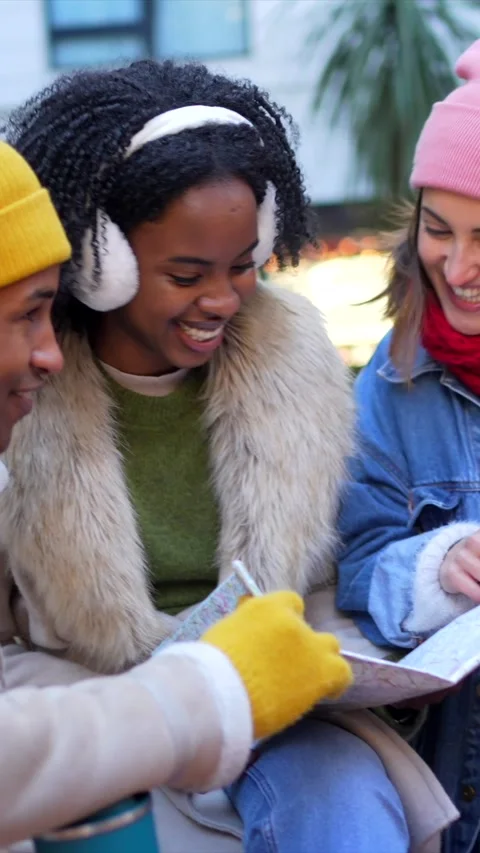 Friends consulting city map during winter vacation Stock Footage 297064350