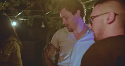 Friends Dancing and Laughing at a Backyard Night Party Under String Lights Stock Footage 314716894