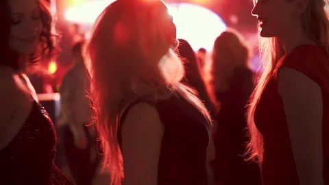 Friends dancing in the rays of red spotlights at a disco in a nightclub. girls Stock Footage 101788656