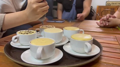 Friends decorating famous Vietnamese egg coffee in coffee shop in Hanoi Vietnam Stock Footage 238715105