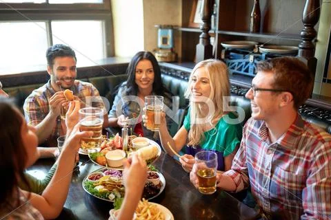 Friends dining and drinking beer at restaurant Stock Photos