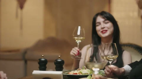 Friends dining in restaurant, clinking glasses with white wine and toasting Stock Footage 227556959