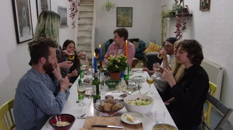 Friends at dinner party leave dining table and enter livingroom Stock Footage 58581982