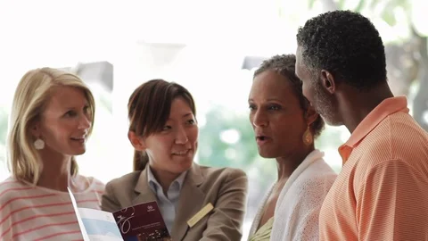 Friends discussing a brochure with a worker. Stock-Footage 88368319