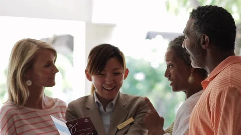 Friends discussing a brochure with a worker. 스톡 동영상 88368326