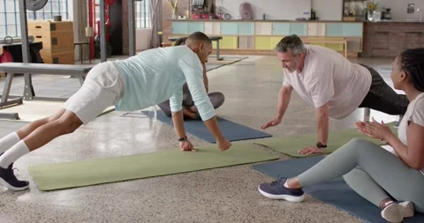 Friends doing plank pushups starting plank in gym men reaching cheering taps Stock Footage 337286816